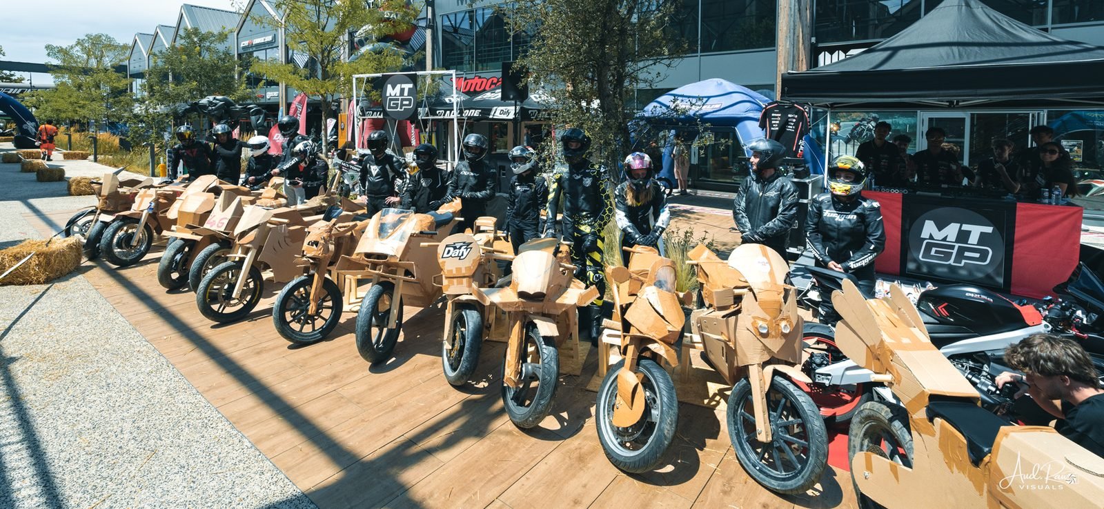 Grille de motos en carton au MotoWNGP, pilotes casqués derrière
