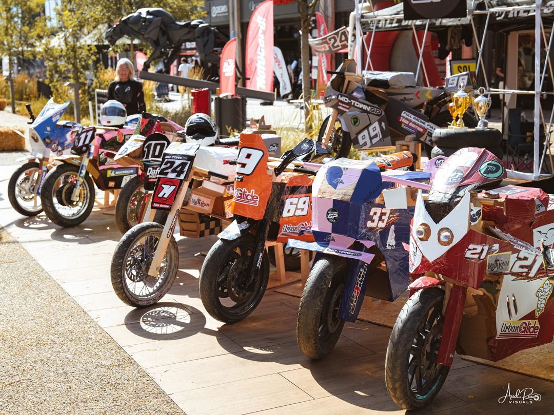 Alignement de motos en carton peintes et numérotées